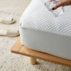 Close-up of a Duradeluxe waterproof mattress protector repelling water, designed for ultimate spill protection, breathability, and comfort. This premium quilted mattress cover safeguards against liquids, allergens, and dust mites, ensuring a hygienic and dry sleep environment.