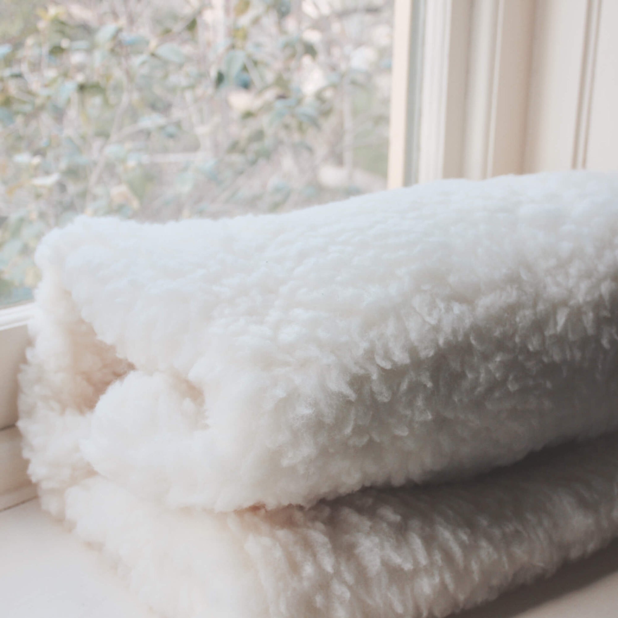 Mattress cot topper for babies made from Australian lambswool with waterproof underside.