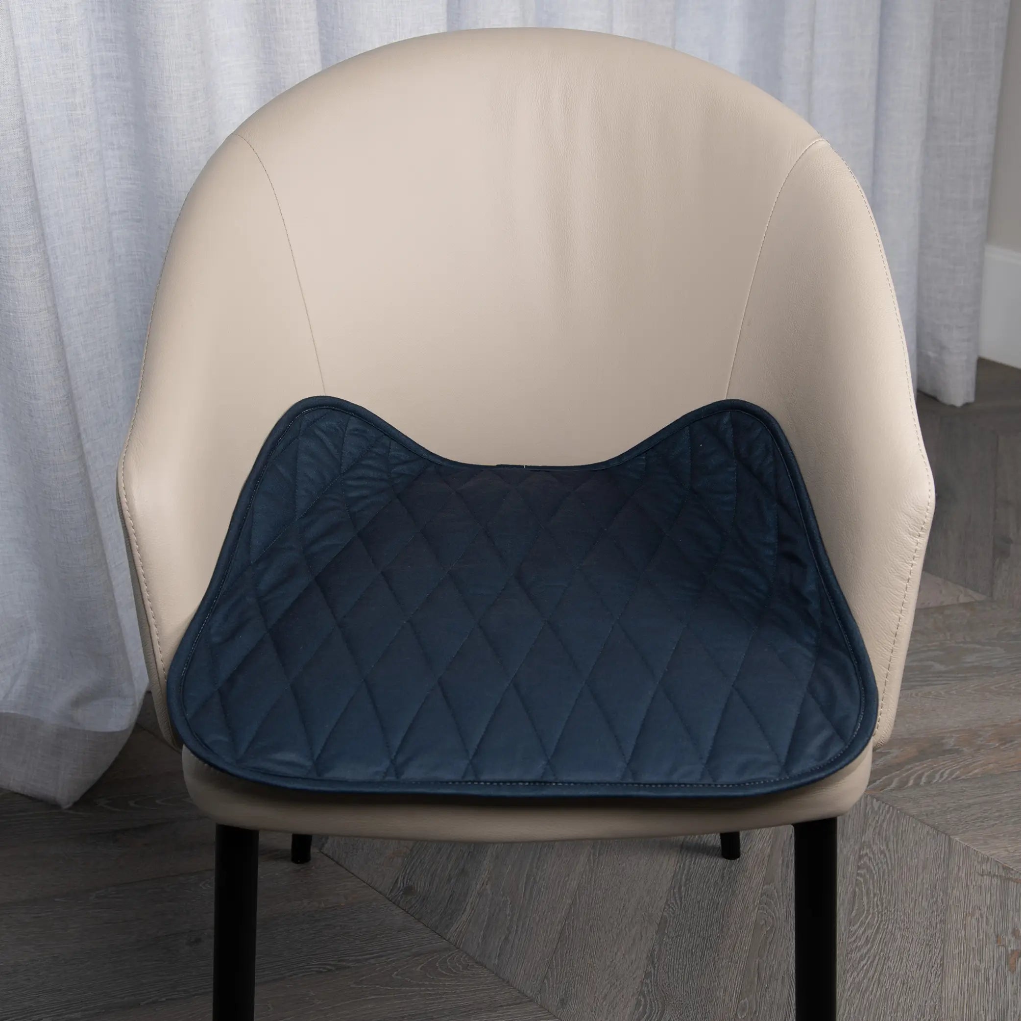 Navy waterproof chair pad placed on a beige upholstered chair, featuring a quilted design for extra comfort and a spill-resistant surface. Ideal for protecting chairs from spills, leaks, and everyday wear, perfect for dining chairs, office chairs, or wheelchairs.