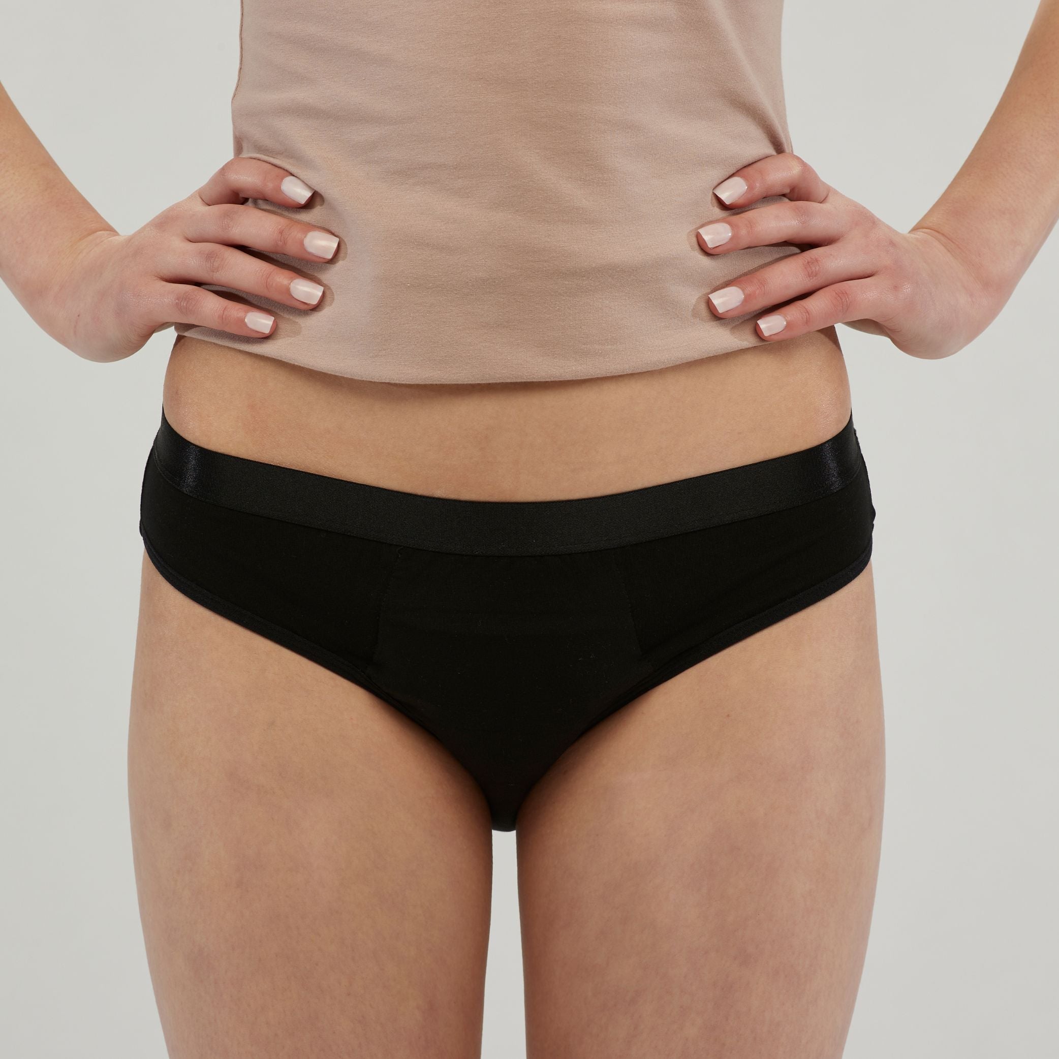 Close-up of a woman wearing black waterproof incontinence hipster underwear with a supportive waistband. Designed for leak-proof protection, comfort and everyday confidence.