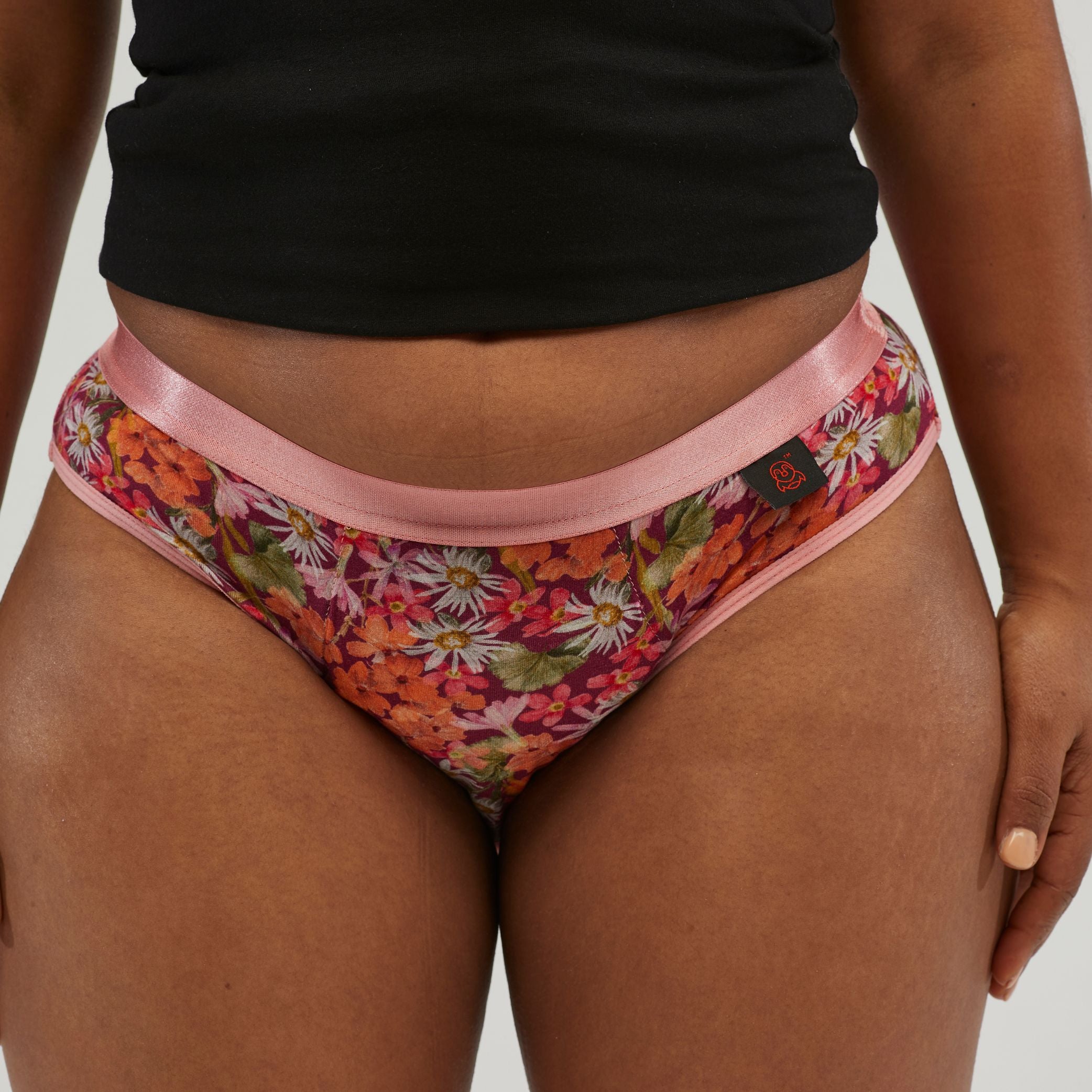 Close-up of waterproof incontinence hipster underwear with a vibrant floral design and soft pink waistband. Designed for comfort, leak protection and everyday wear