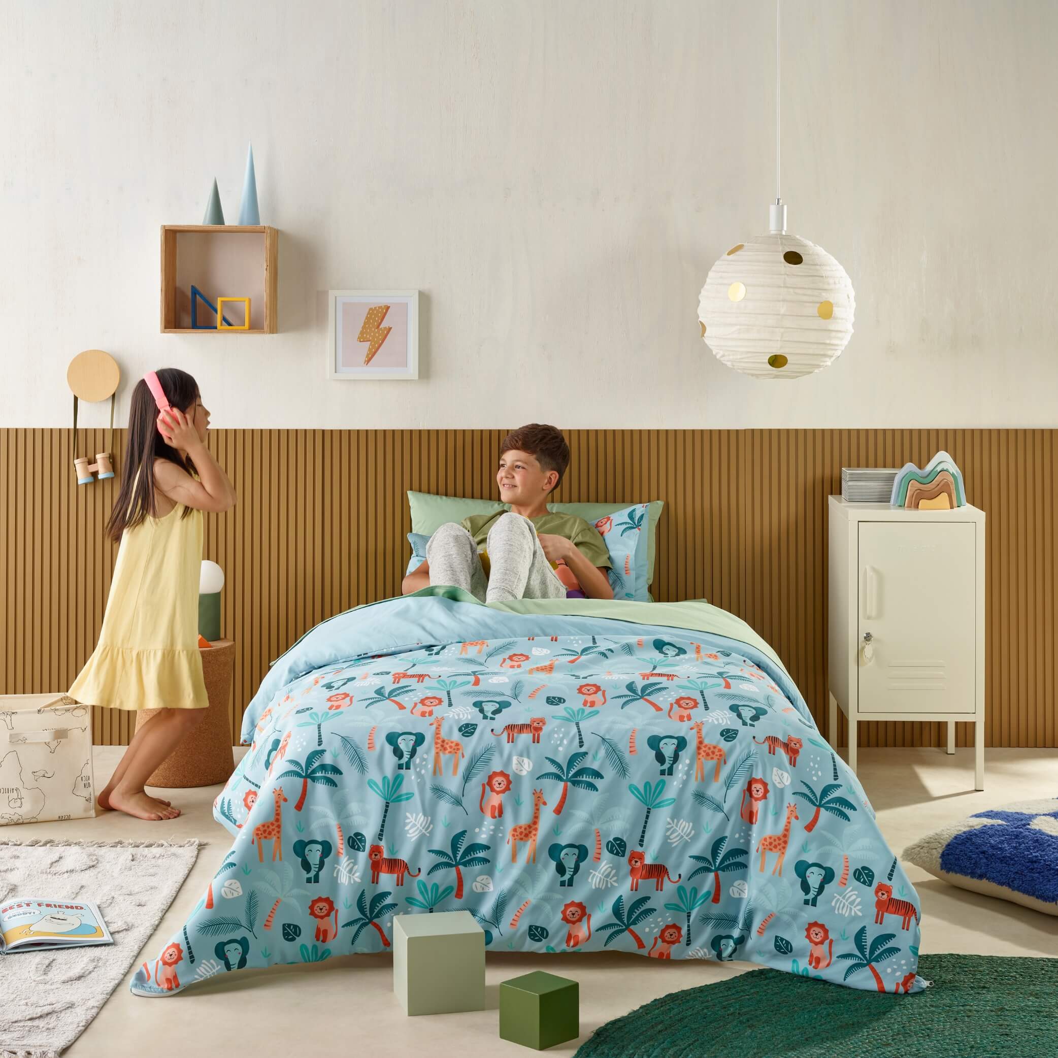 Kids playing in bedroom with jungle animal print waterproof bedding